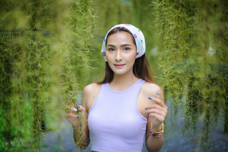 Portrait of beautiful young woman standing on land