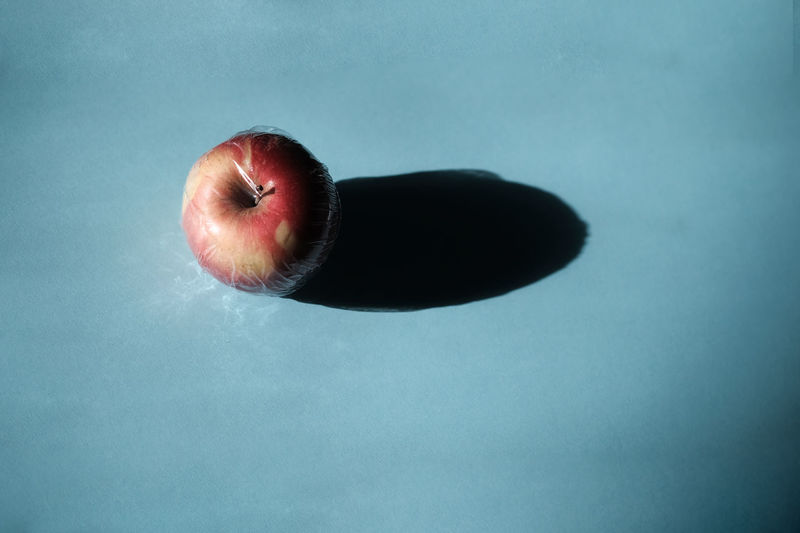 Close-up of apple on table against blue background