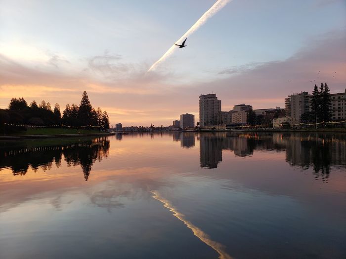 Reflection of buildings in lake during sunset