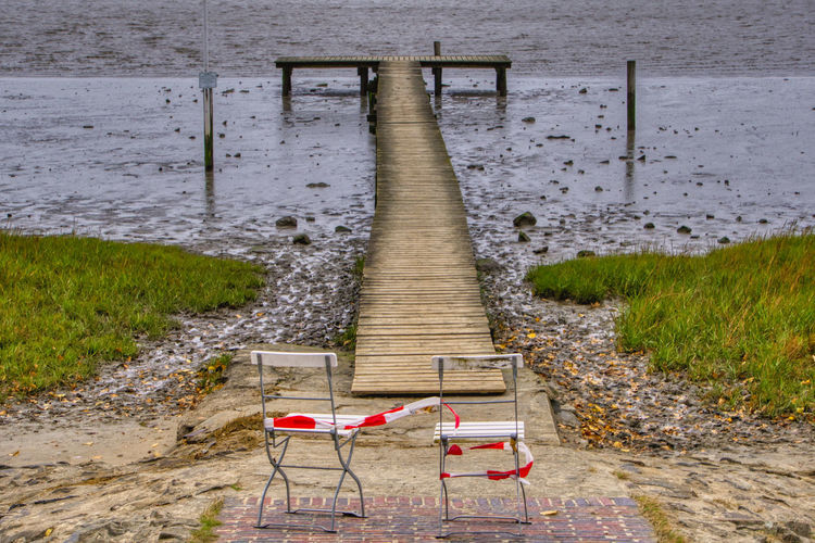 Chair on footpath by lake