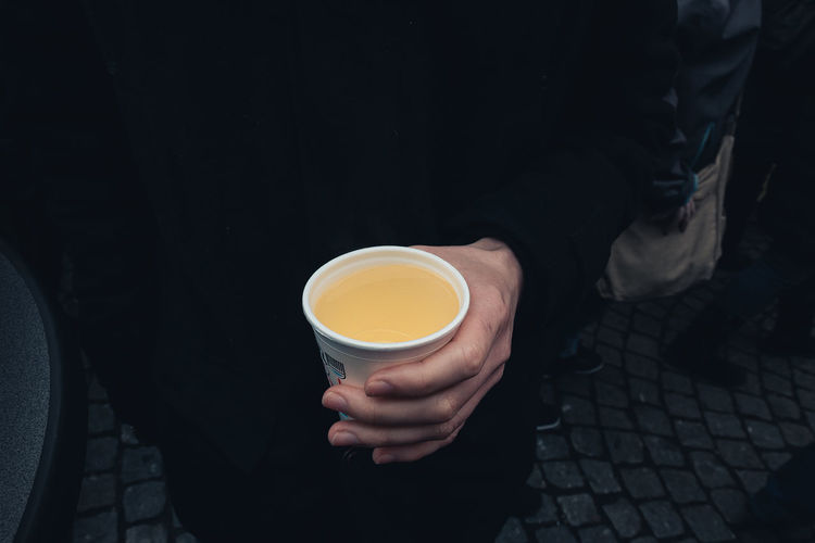 Low section of woman holding coffee cup