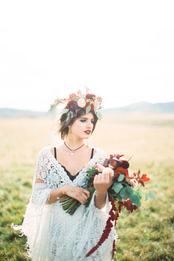 Young woman with bouquet in field