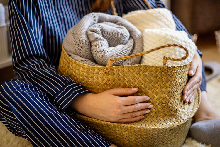 Midsection of woman with clothes in basket