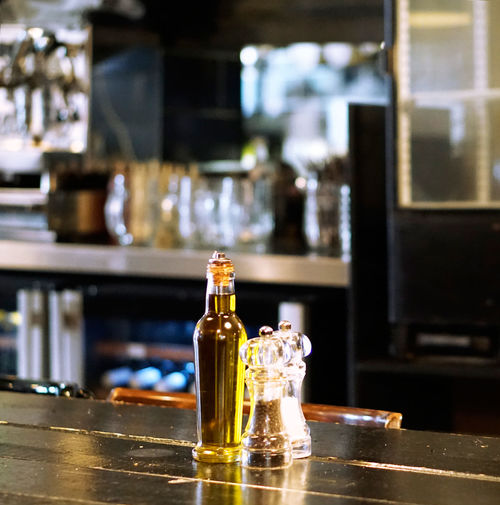 Olive oil with salt and pepper shakers on table in kitchen