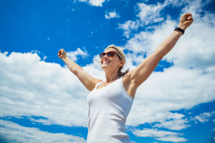 Low angle view of woman standing against sky
