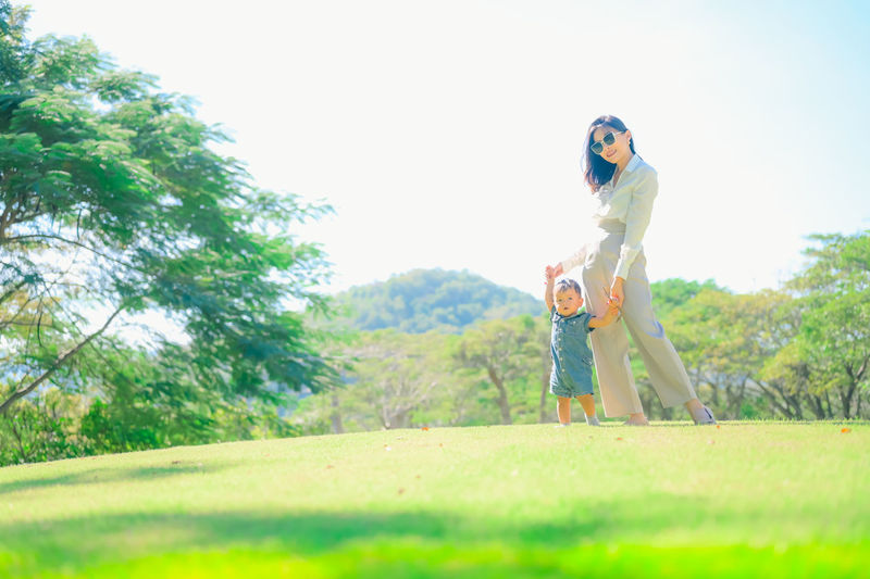 Full length of woman standing on field against sky