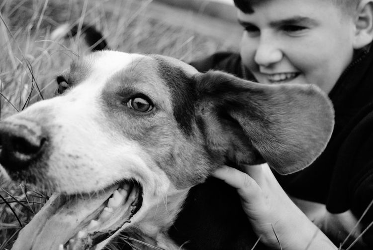 Smiling teenage boy touching dog