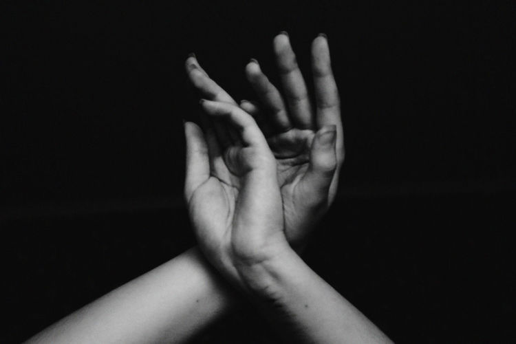 Cropped image of woman hands against black background