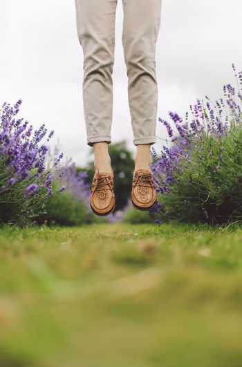 Low section of woman jumping in field of lavender