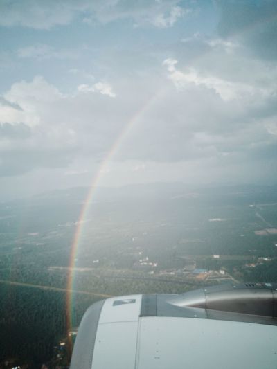 Aerial view of rainbow over landscape against sky