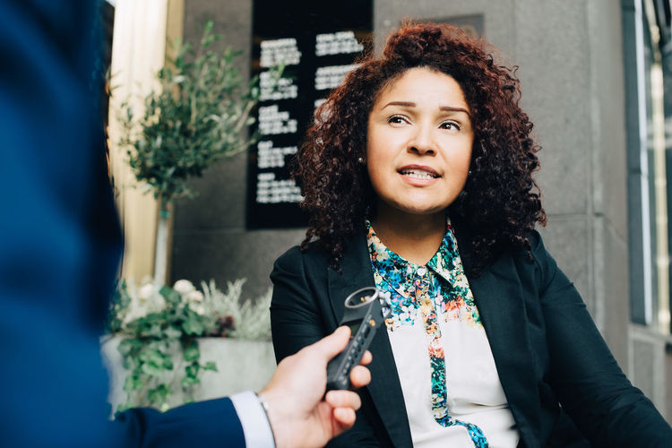Cropped image of man interviewing businesswoman in city