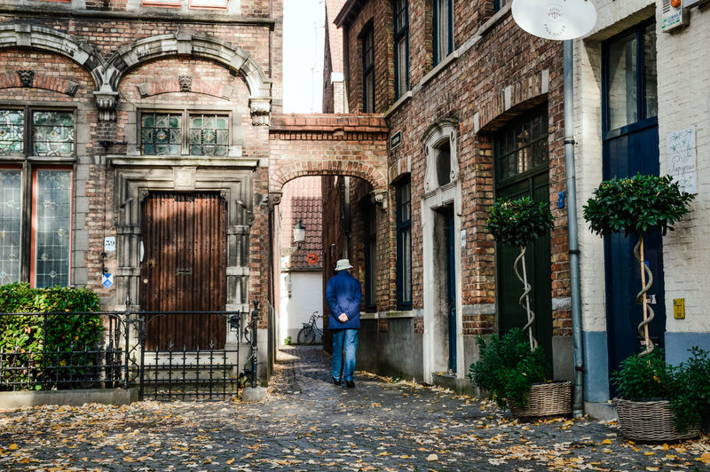 Rear view of man walking on old building
