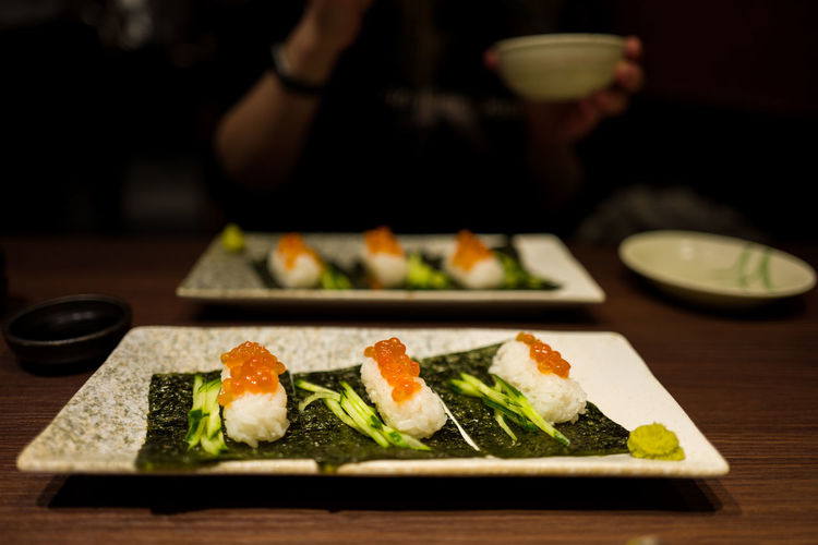 Close-up of fresh sushi served in plates on table at restaurant