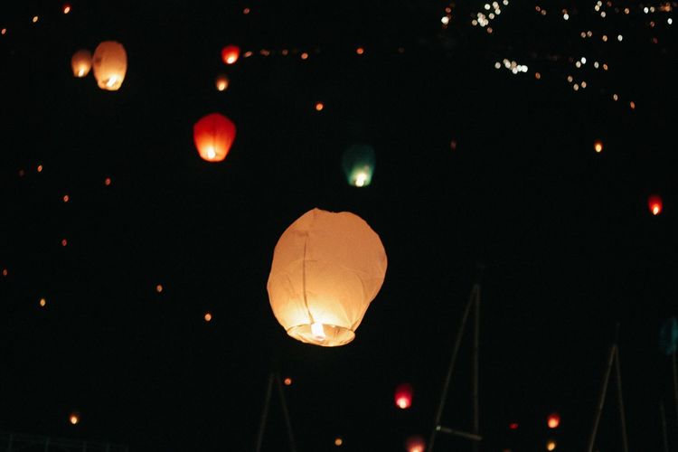 Low angle view of illuminated lantern against sky at night