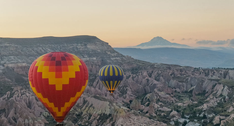 Hot air balloon over mountains against clear sky