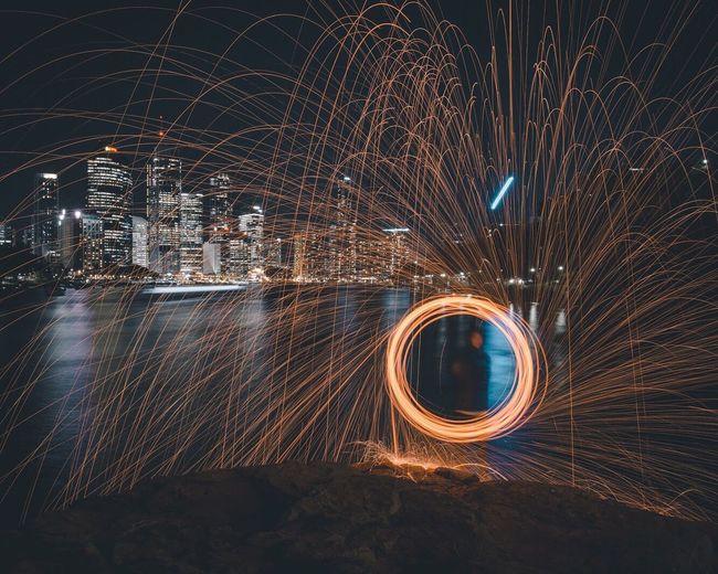 Person spinning wire wool at night