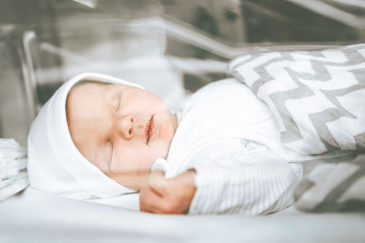 Cute baby sleeping on bed at home