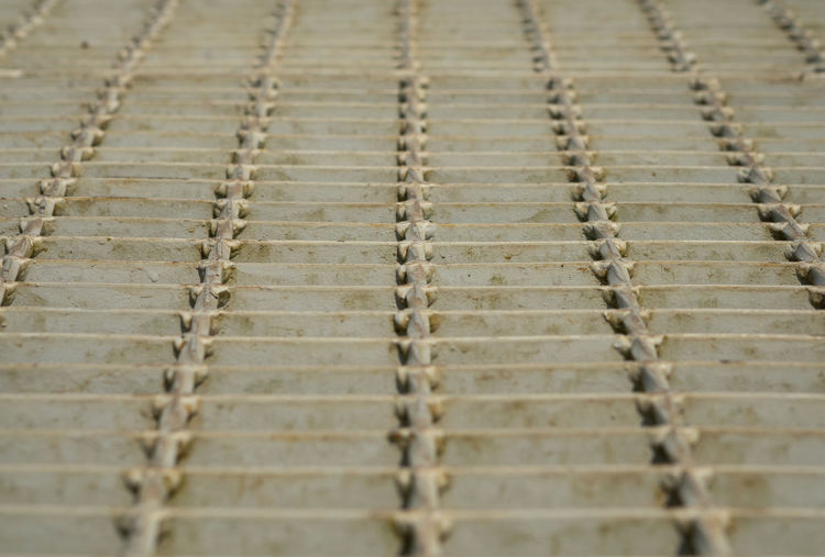 Low angle of outdoor metal grating walkway on sunlight warm lighting.