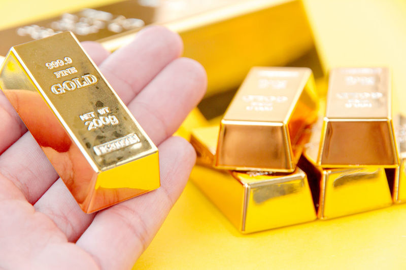 Close-up of hand holding gold bar
