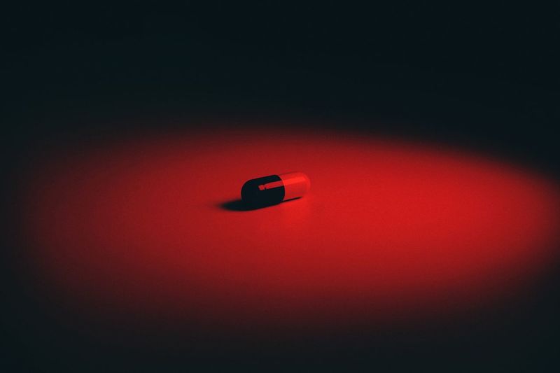 Close-up of red light on table against wall