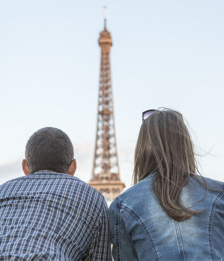 Rear view of couple against eiffel tower and clear sky