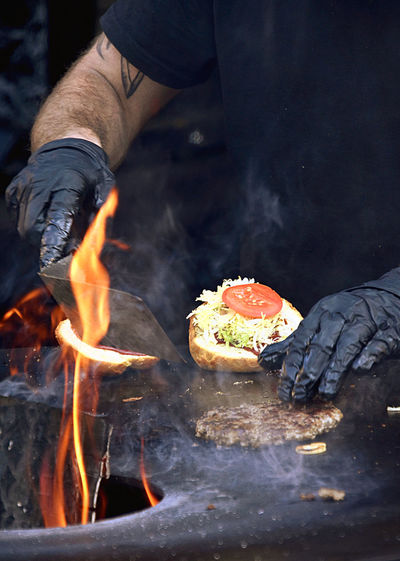 Midsection of man preparing food on barbecue grill