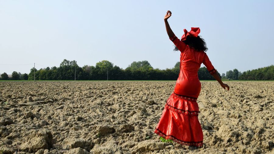 Woman in red dress walking on land