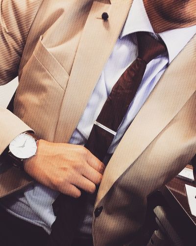 Midsection of businessman holding necktie