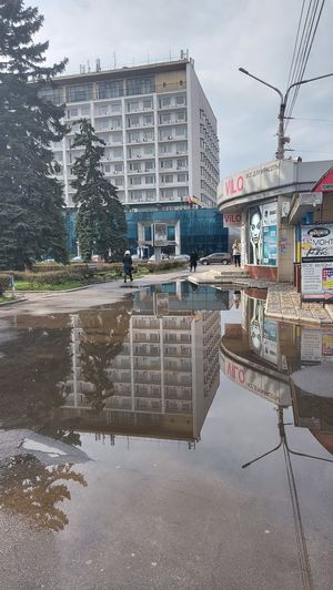 Reflection of buildings in puddle on road