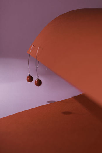 Modern stud geometric earrings on red paper background.