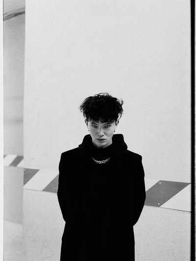 Portrait of young man standing against wall