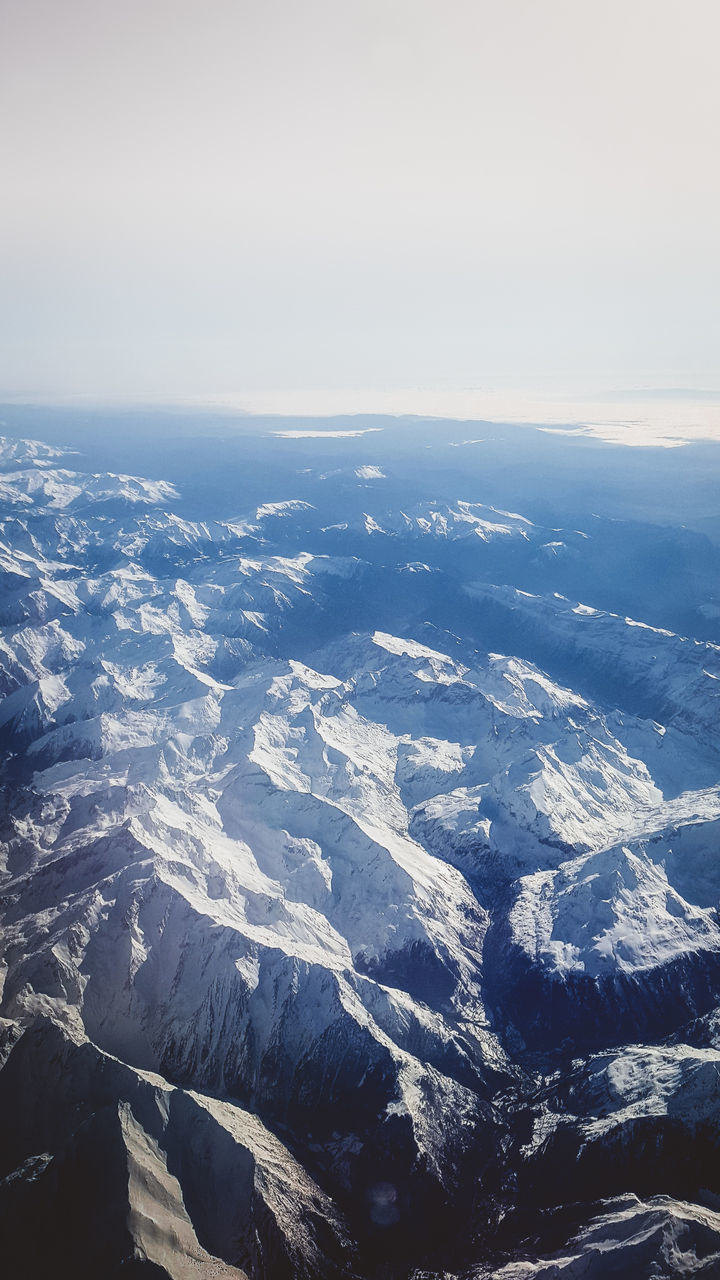 AERIAL VIEW OF SNOW COVERED LANDSCAPE AGAINST SKY