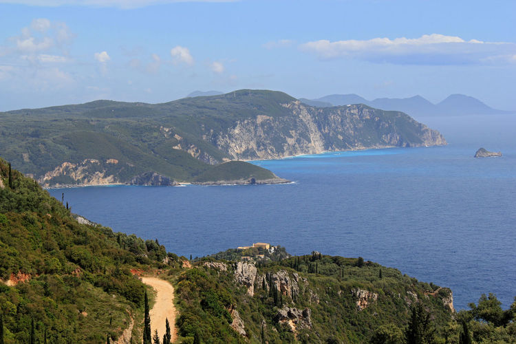 Scenic view of sea and mountains against sky