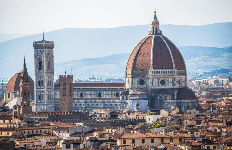 View of florence cathedral amidst buildings against mountain