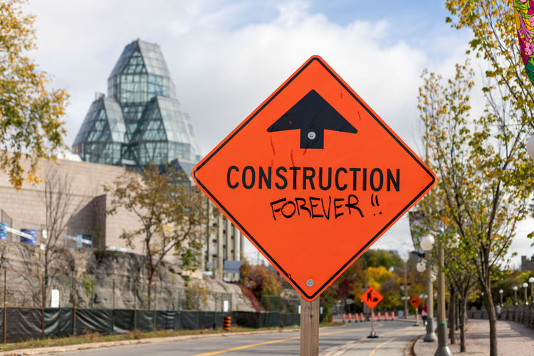 Warning construction ahead orange road sign in downtown of ottawa, canada