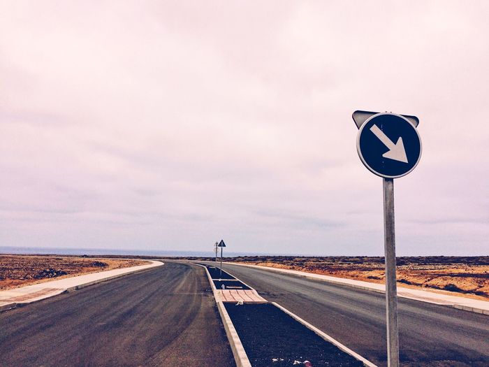 Road sign against sky
