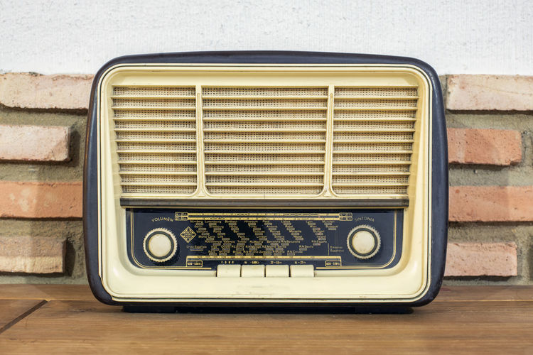 Close-up of vintage radio on table against wall