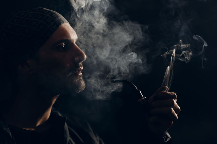 Portrait of young man smoking cigarette