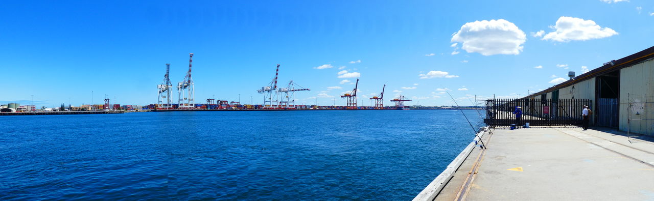 Panoramic view of commercial dock against blue sky