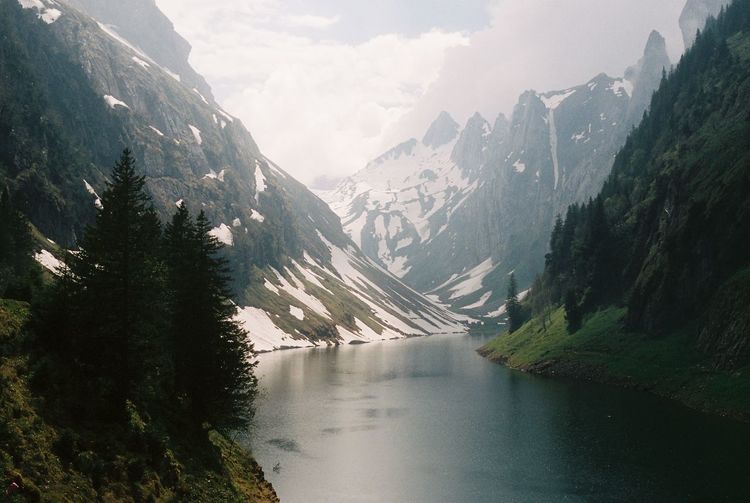 Scenic view of lake amidst mountains against sky