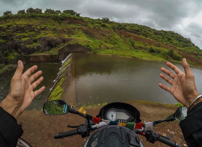 Midsection of man by river against mountain