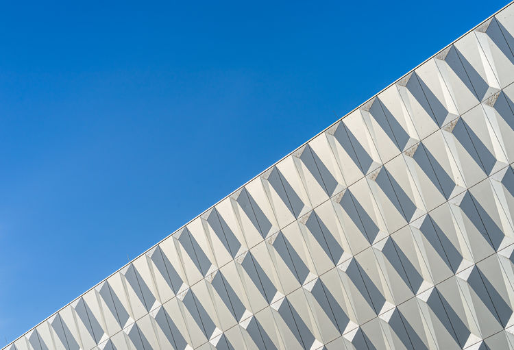 Low angle view of modern building against clear blue sky