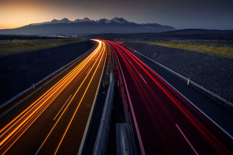 Light trails on highway during sunset