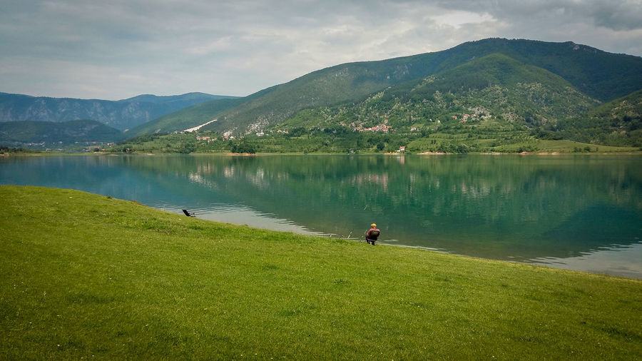 A man sitting by the lake and fishing