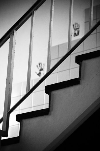 Low angle view of handprints on wall seen through railing