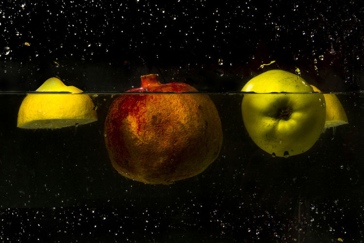 Close-up of fruits in water against black background