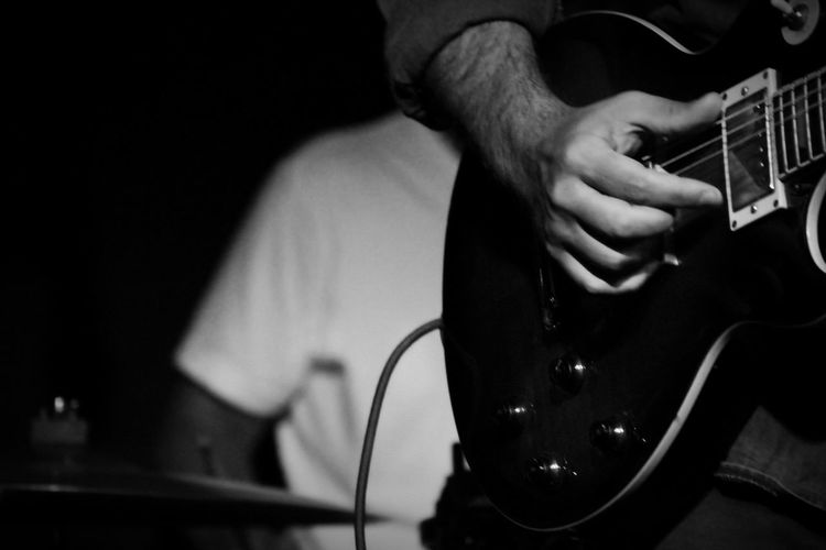 Midsection of man playing guitar