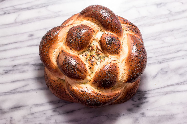 Braided round challah bread loaf with poppy seeds