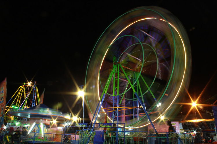 Illuminated ferris wheel at night