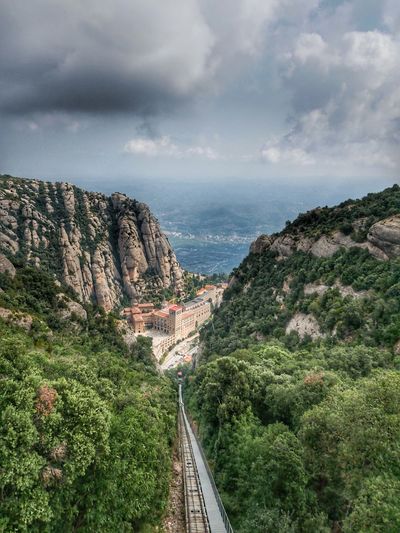 Aerial view of railroad tracks amidst mountains against sky